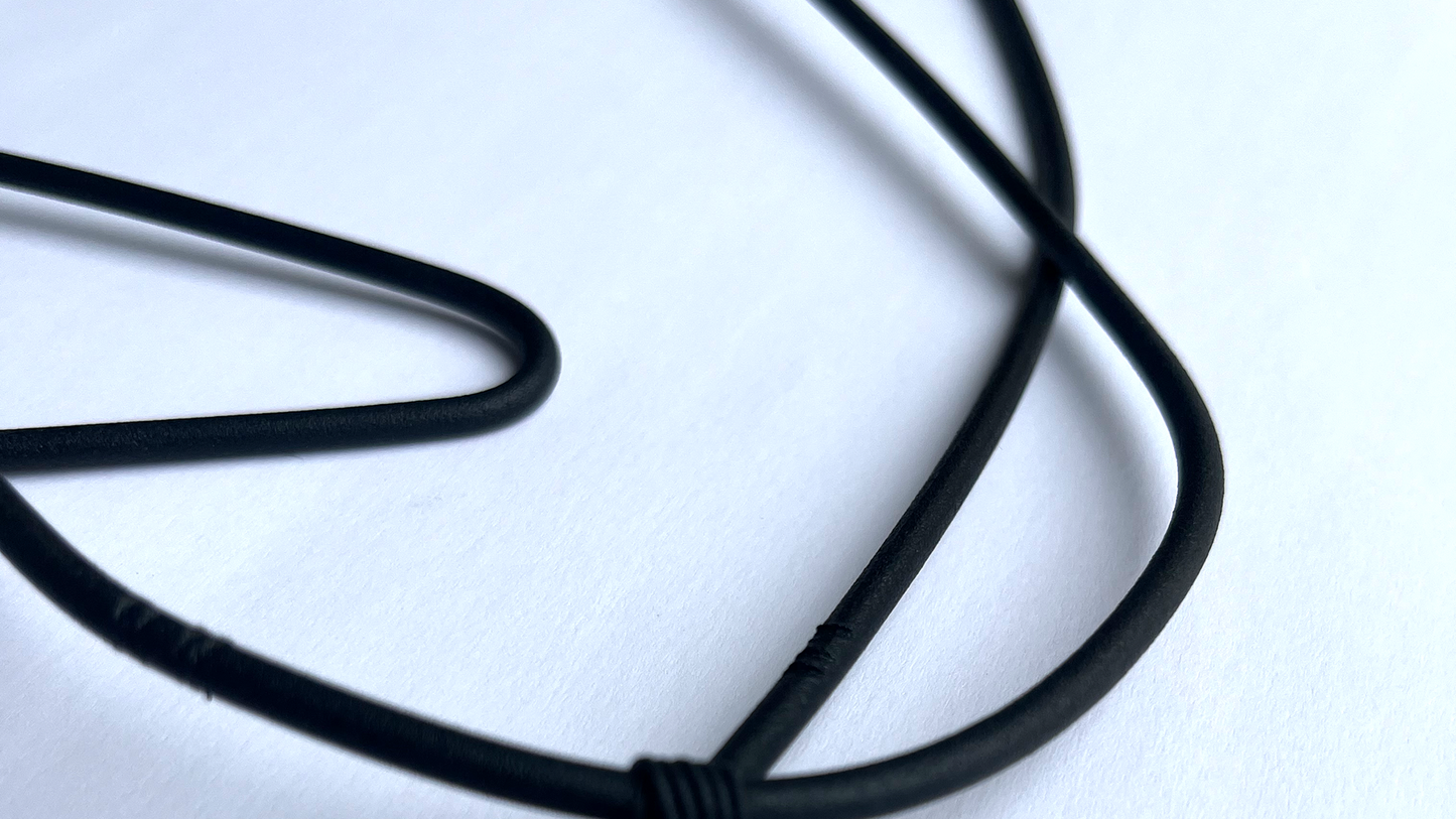a close up image of black bent black steel wall art on white background with shadows