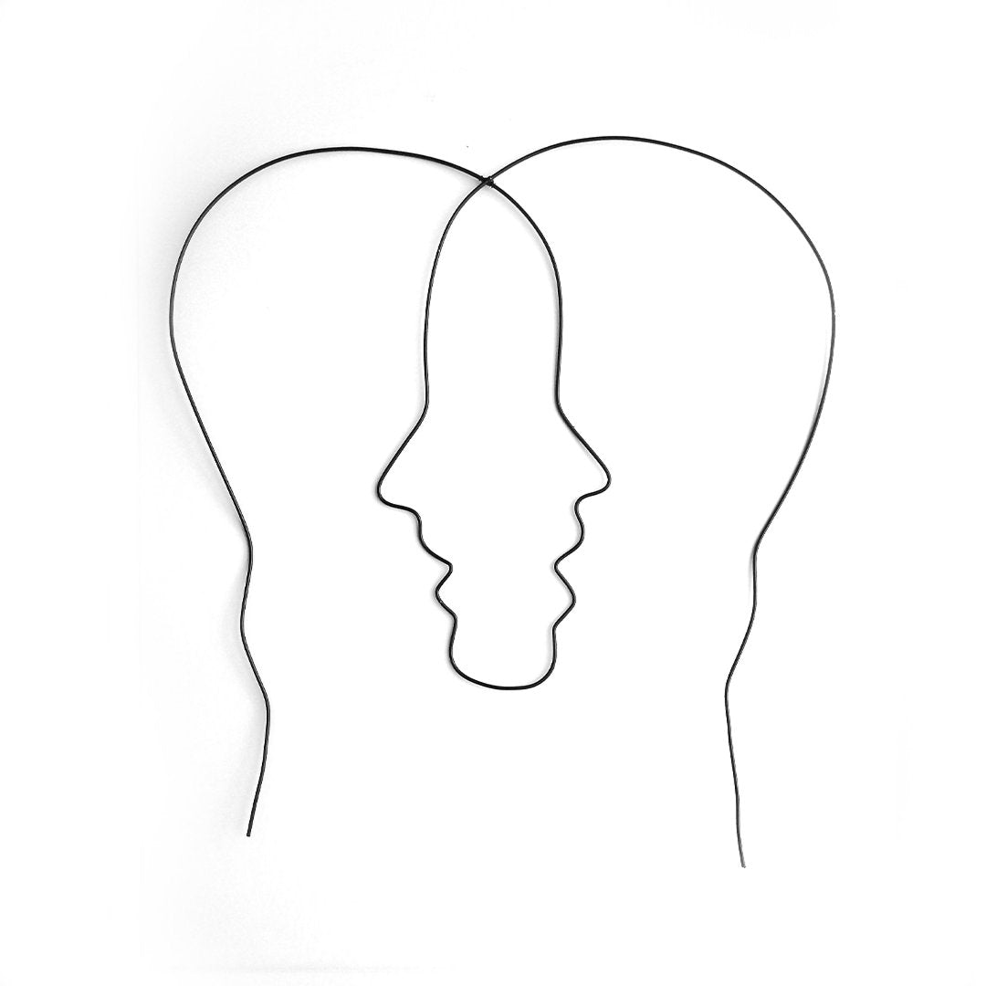 The abstract steel wall art by Living Things Creative features a minimalist line drawing of two overlapping profiles forming a central face, creating a visual illusion. Locally handcrafted and powder coated in black for durability, this piece stands out against a white background, emphasizing the simplicity and elegance of its design.